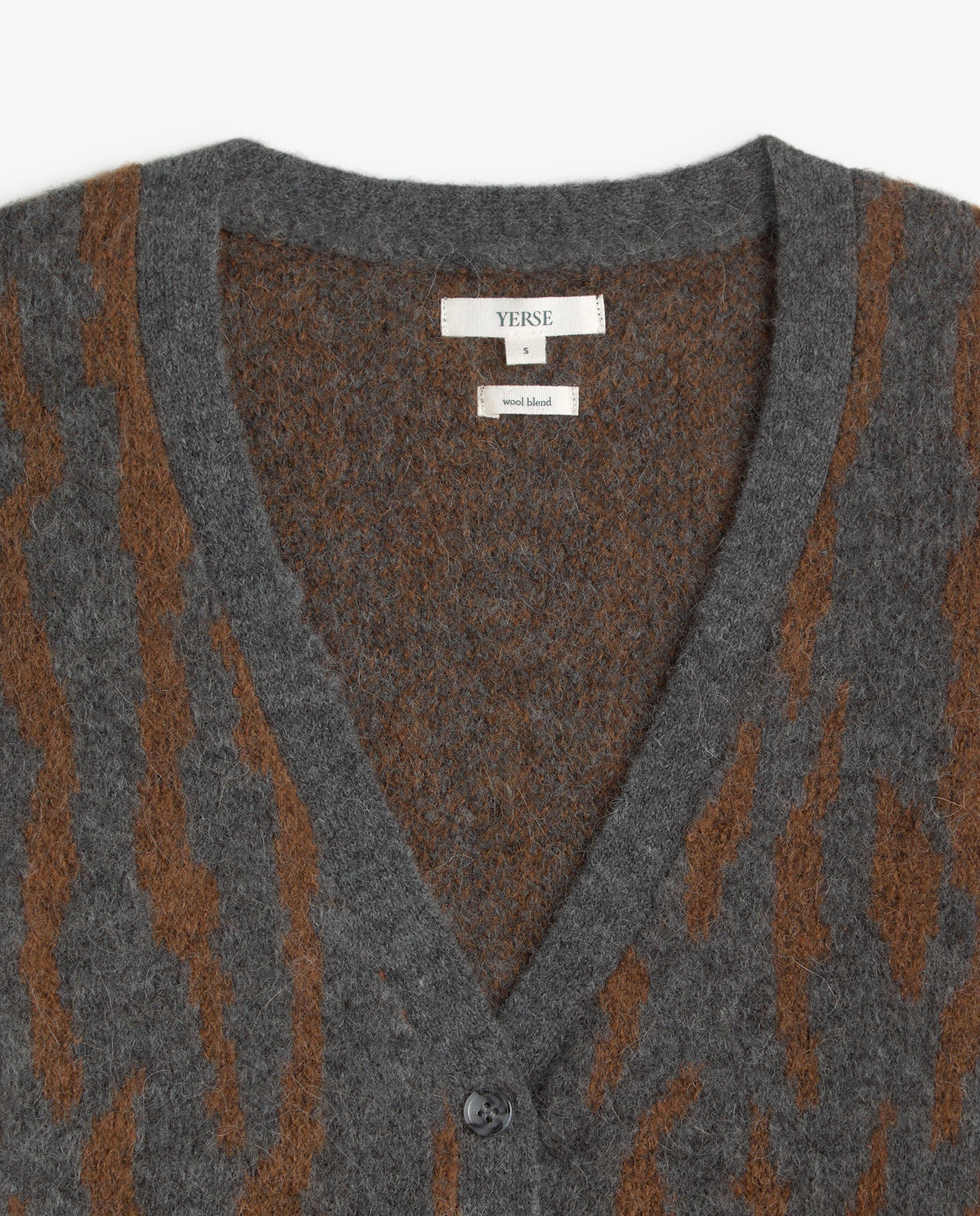 Close-up of a gray and brown patterned V-neck cardigan sweater by Yerse, showing the brand label and button closure.