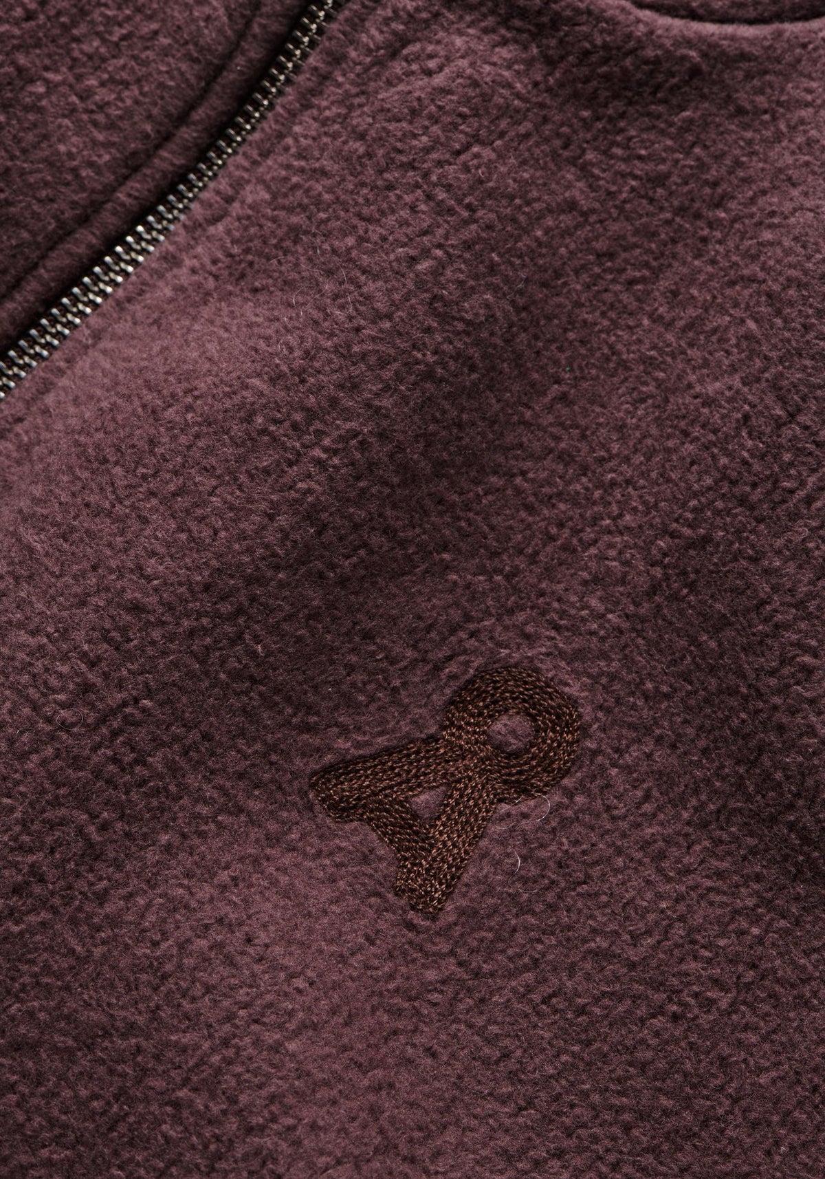 Close-up of a textured purple fabric with a logo on a jacket
