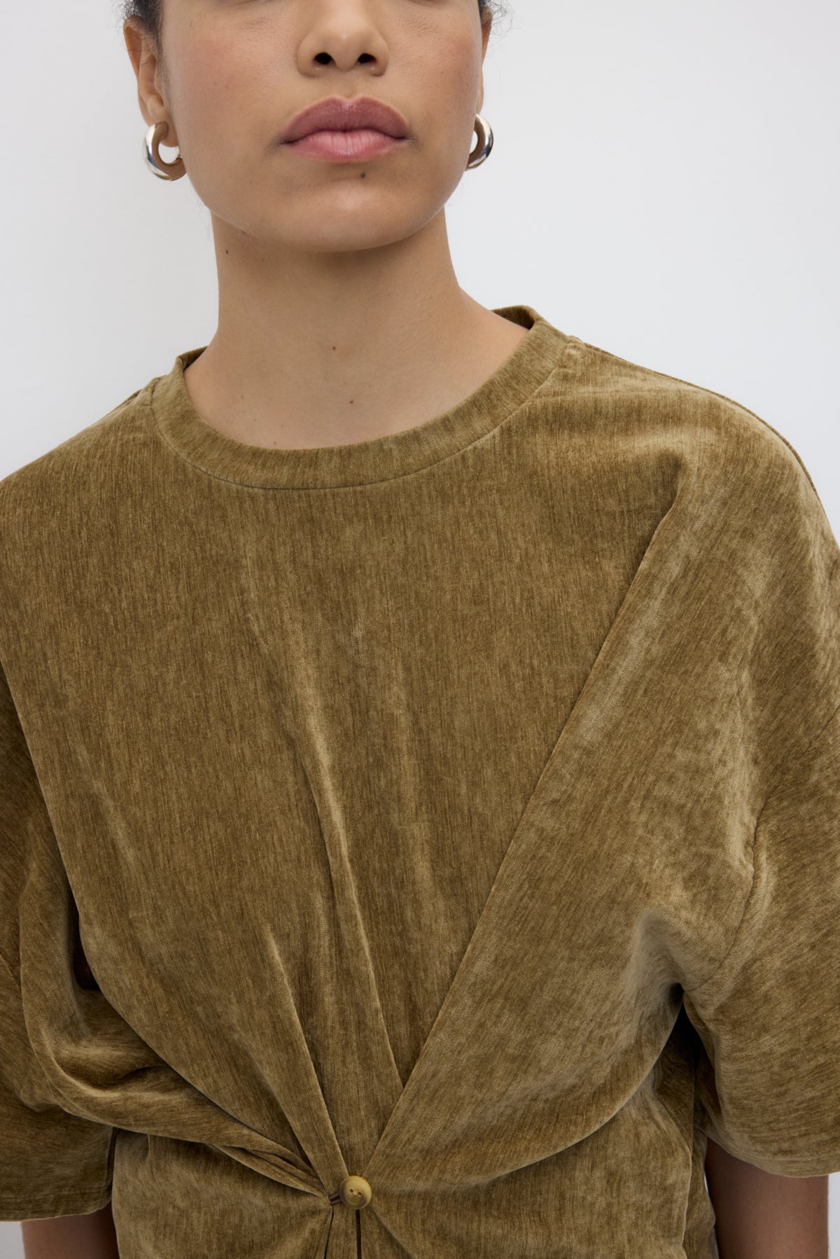 Brown velvet top worn by a person on a white background