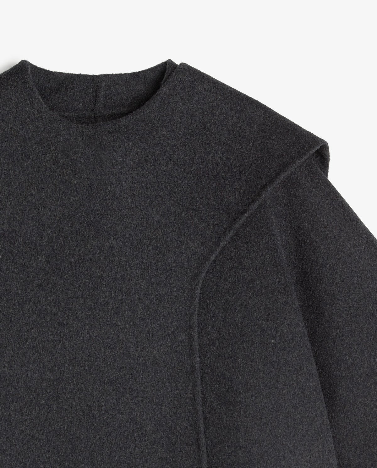 Close-up of a dark charcoal gray knit top showing the crew neck and shoulder seam details against a light gray background.