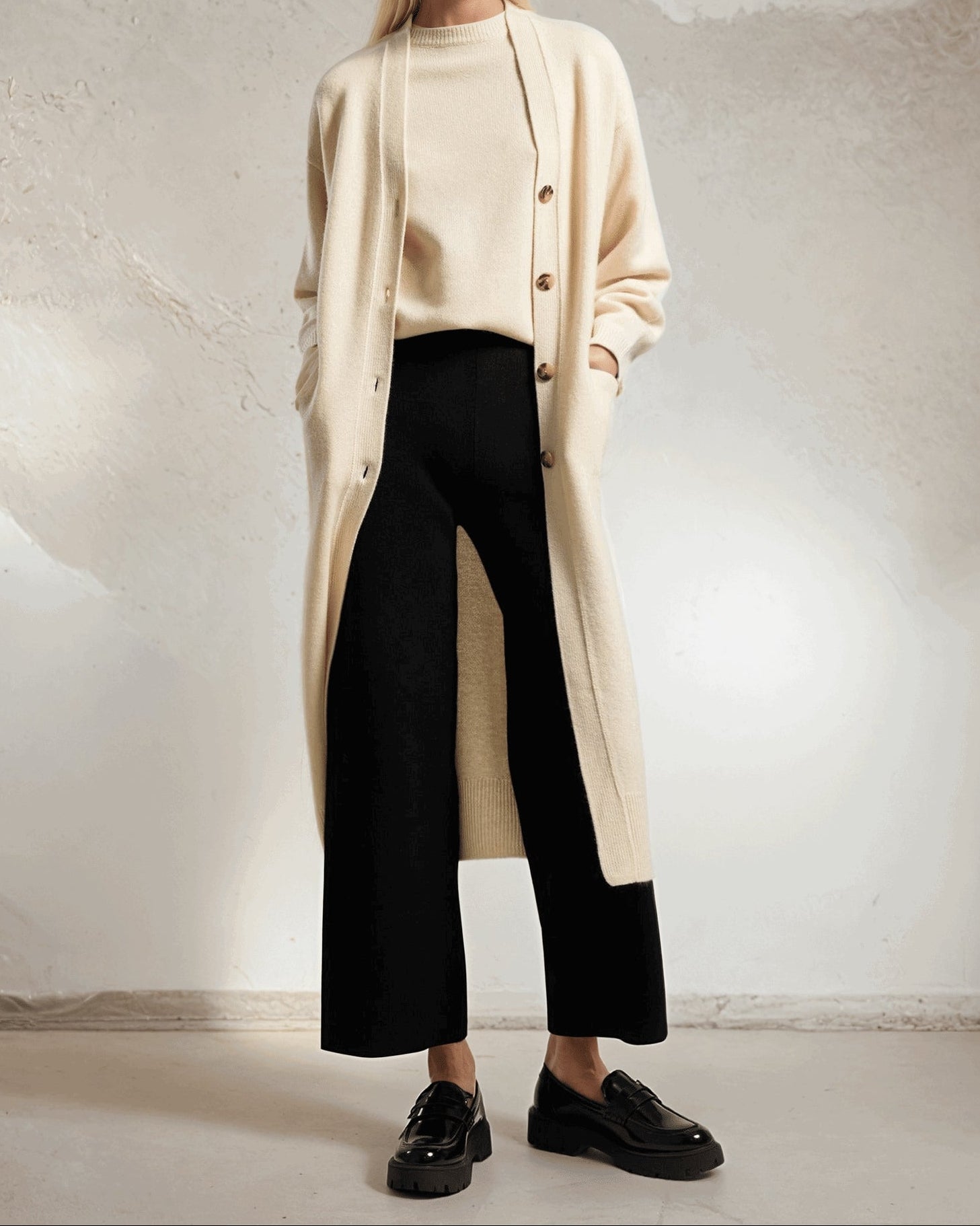 Black cashmere cropped pants worn, highlighting soft texture and modern ankle-length style.
