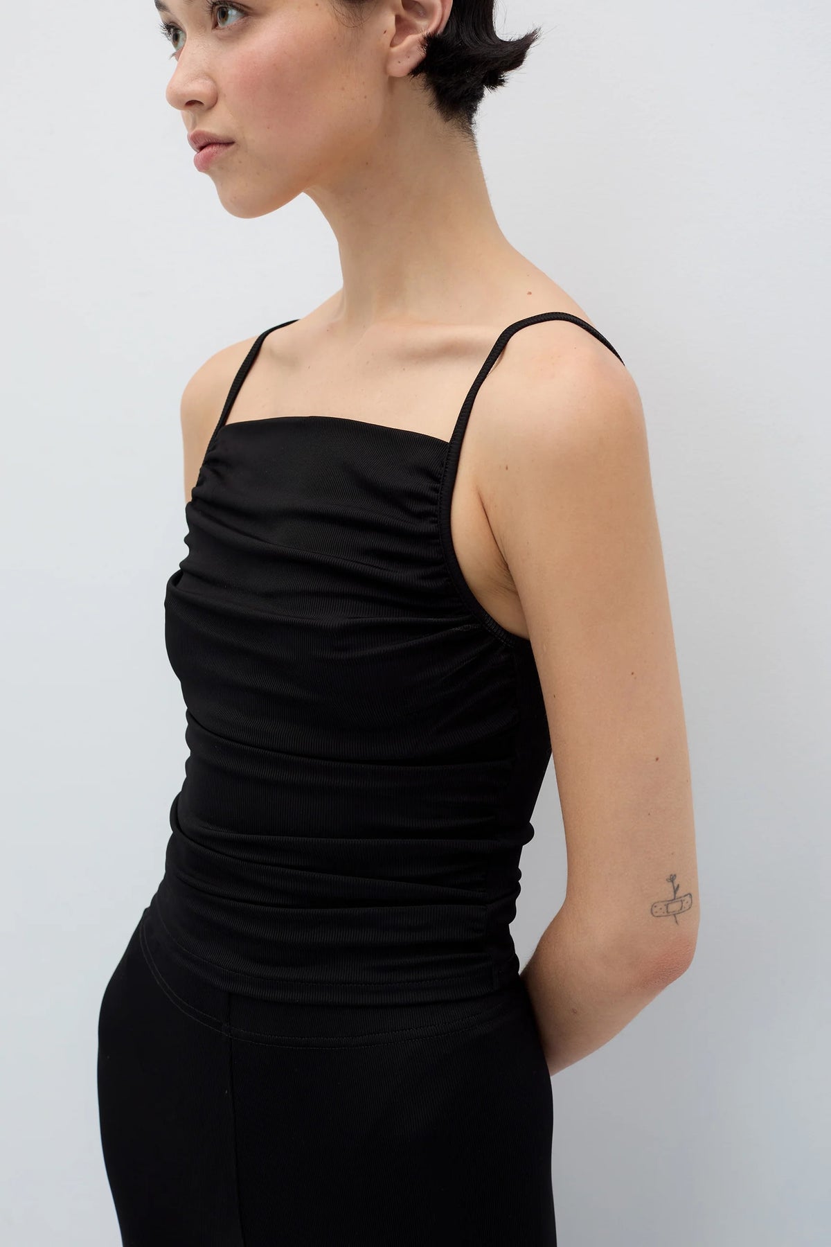 Woman wearing a black dress against a plain background