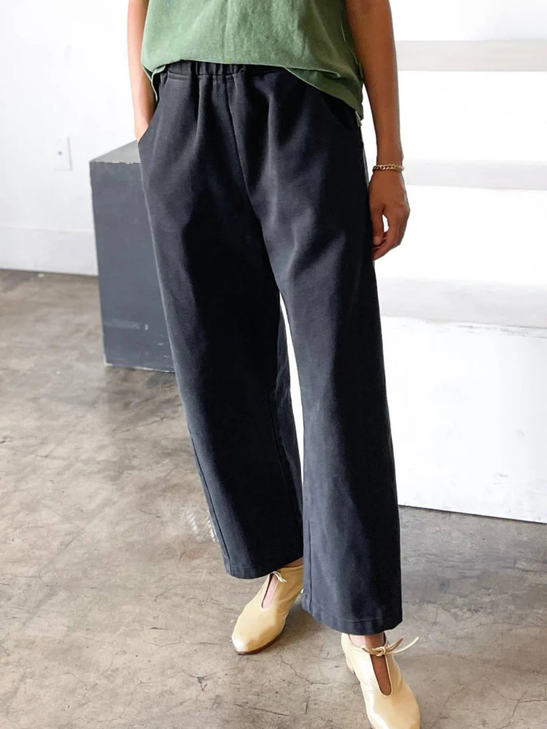 Model wearing black canvas arc pants with a relaxed, modern fit