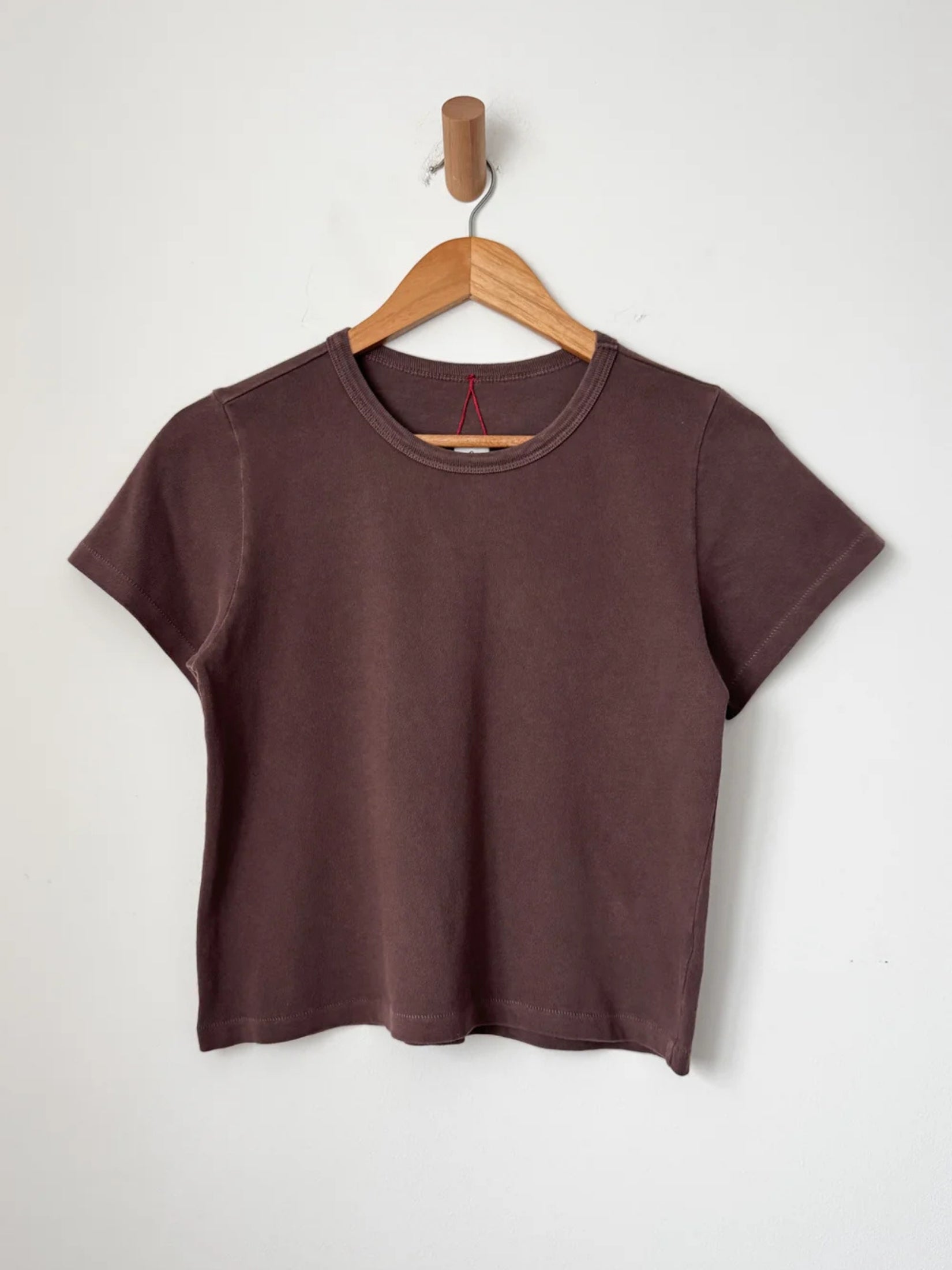  a brown cotton t-shirt, highlighting its simple and casual design.