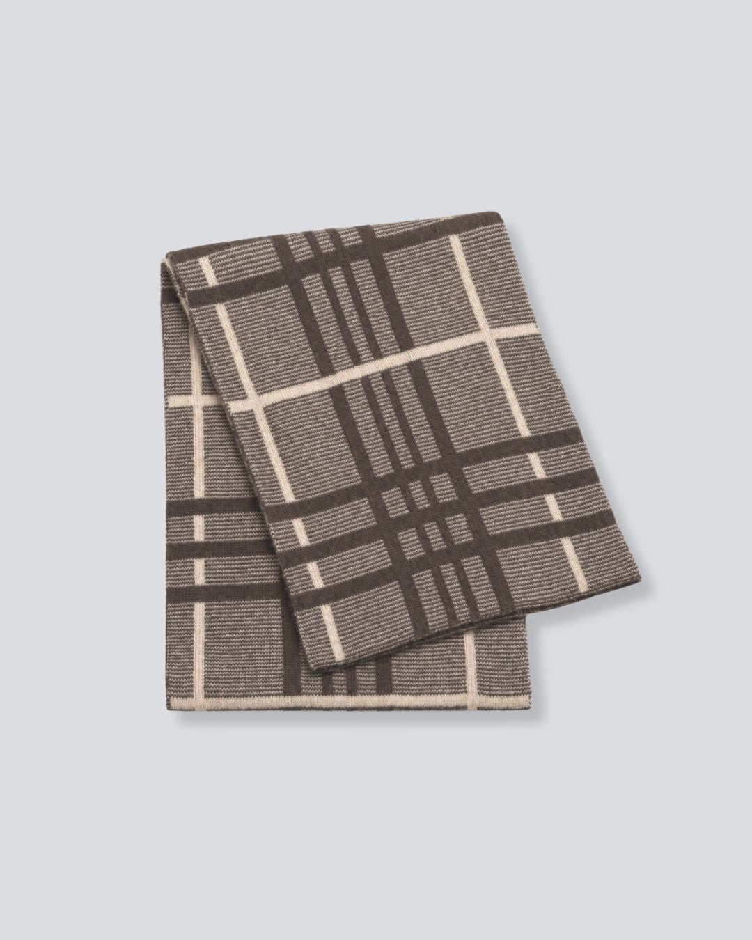 A folded woven throw blanket featuring a brown and beige plaid pattern, displayed on a solid light gray background.